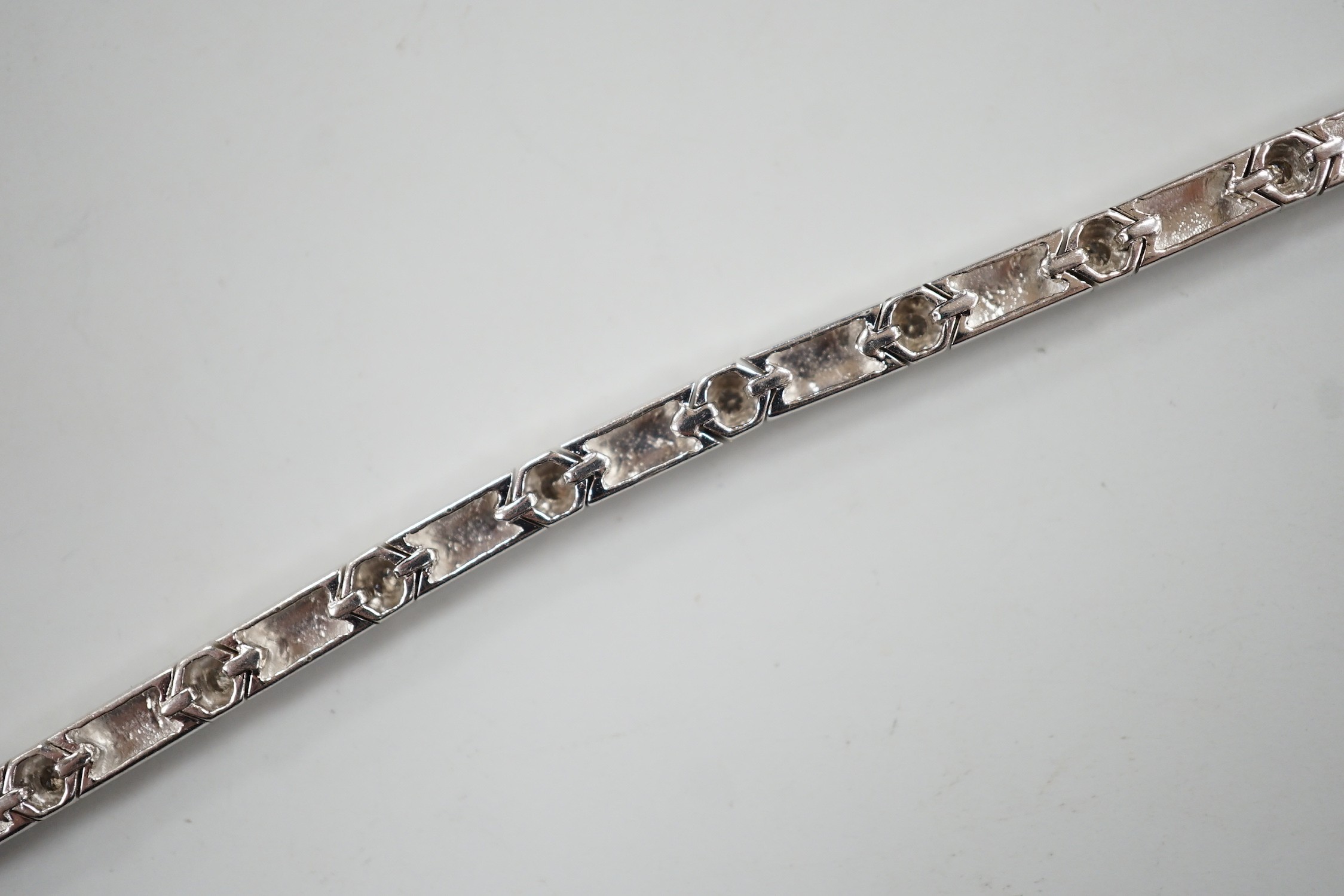 A modern 18k white metal and diamond chip set line bracelet, 15cm, gross weight 10.4 grams.